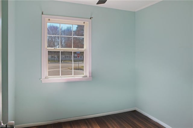 spare room with dark wood-style floors, plenty of natural light, and baseboards