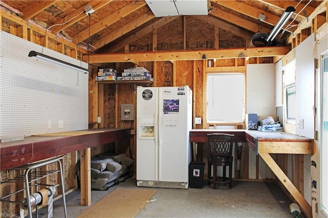 garage with white fridge with ice dispenser and a workshop area