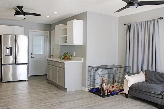 kitchen with ceiling fan, open shelves, light wood finished floors, and stainless steel refrigerator with ice dispenser