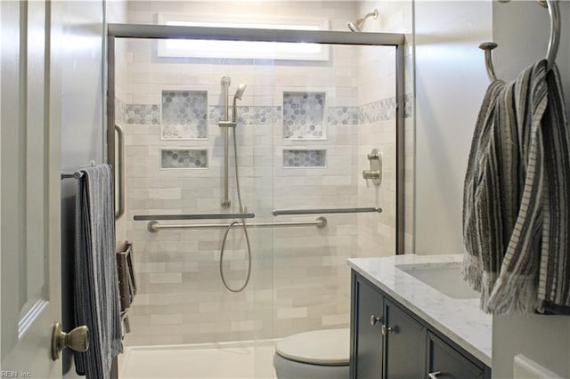 full bath featuring toilet, a stall shower, and vanity