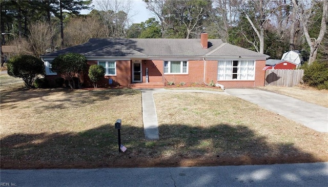 ranch-style house with a front yard, brick siding, fence, and a chimney