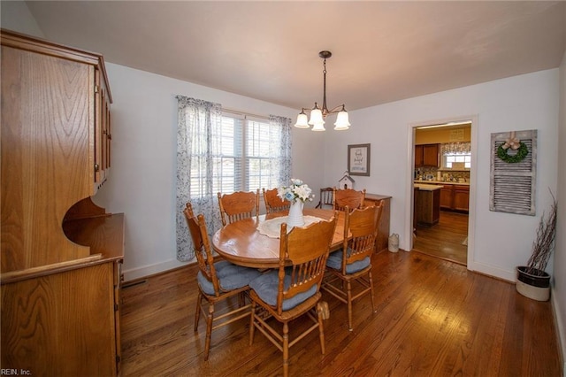 dining area with an inviting chandelier, baseboards, and wood finished floors