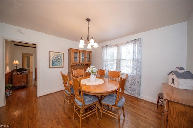 dining room with an inviting chandelier, baseboards, and wood finished floors