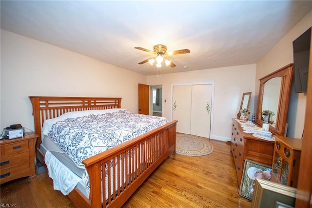 bedroom with ceiling fan, a closet, baseboards, and wood finished floors