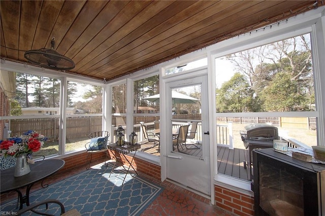 sunroom / solarium featuring wooden ceiling and a healthy amount of sunlight