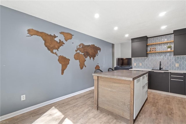 kitchen featuring a kitchen island, a sink, open shelves, and modern cabinets