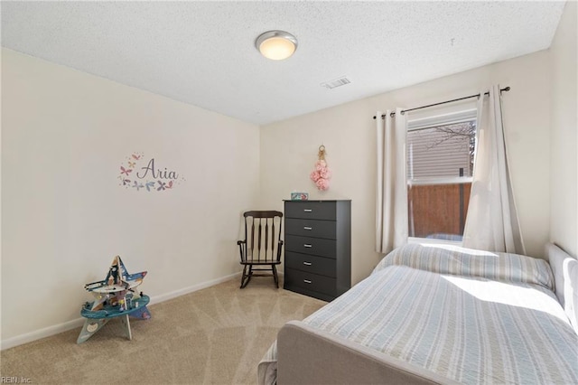 carpeted bedroom featuring a textured ceiling, visible vents, and baseboards