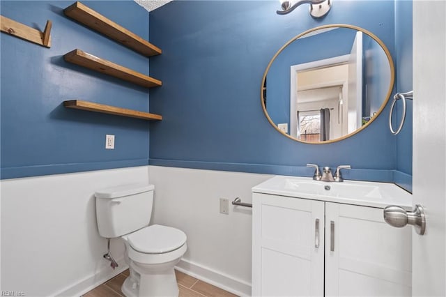 bathroom with vanity, toilet, and baseboards