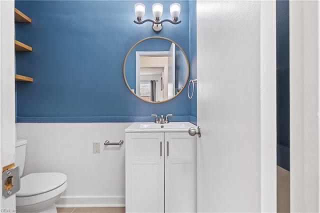 bathroom featuring toilet, tile patterned floors, baseboards, and vanity