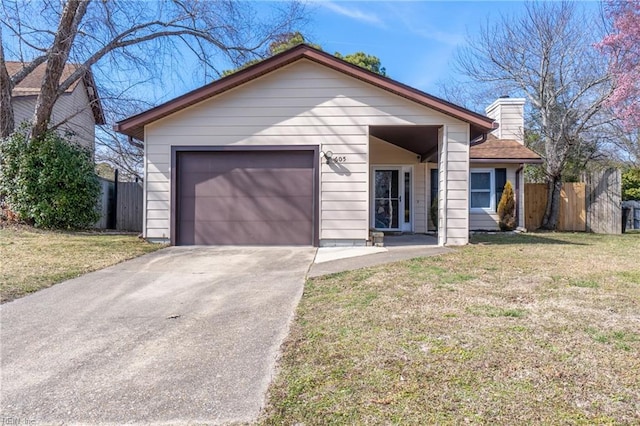 view of front of home featuring a front yard, fence, driveway, and an attached garage