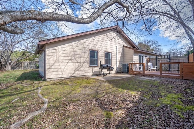 rear view of house featuring fence, a patio, a wooden deck, and central air condition unit