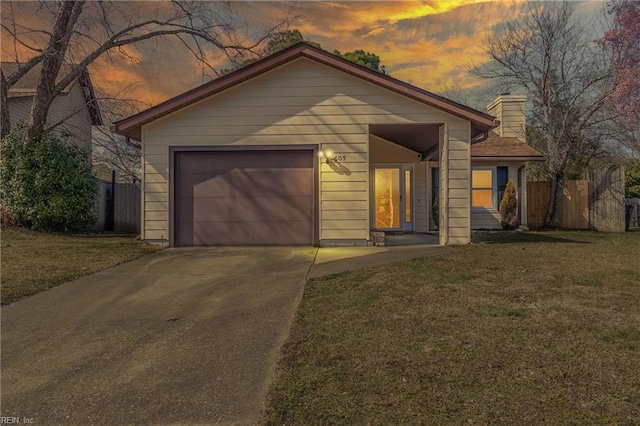 view of front of property featuring an attached garage, fence, a front lawn, and concrete driveway