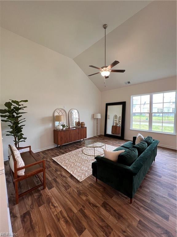 living area featuring visible vents, baseboards, ceiling fan, wood finished floors, and high vaulted ceiling