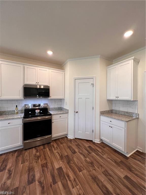 kitchen with decorative backsplash, dark wood-style floors, appliances with stainless steel finishes, crown molding, and white cabinetry