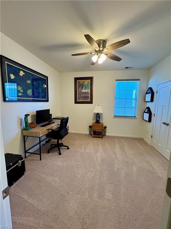 office area featuring a ceiling fan, carpet, visible vents, and baseboards