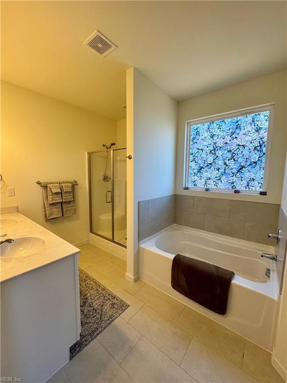 bathroom featuring visible vents, a sink, a garden tub, and tile patterned floors