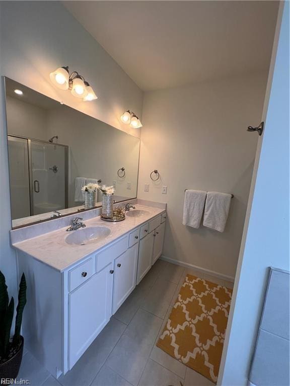 full bathroom featuring double vanity, tile patterned flooring, a sink, and a shower stall