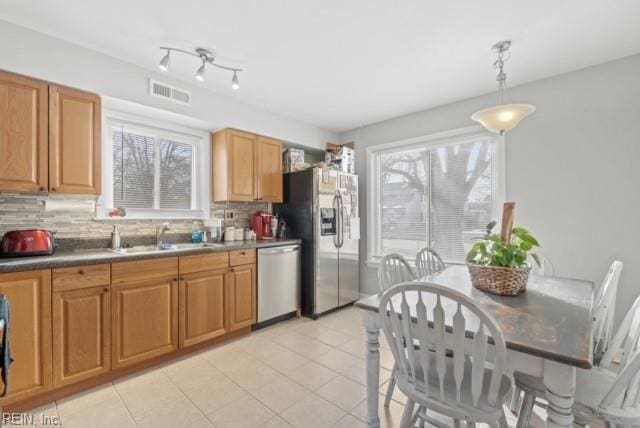 kitchen with stainless steel appliances, a healthy amount of sunlight, a sink, and visible vents