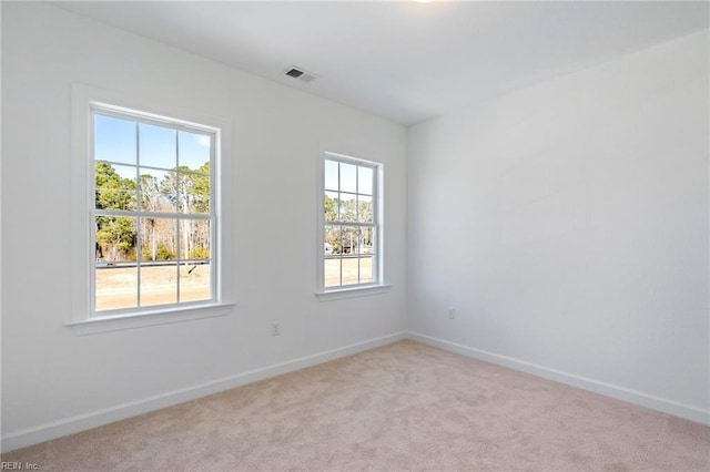 unfurnished room featuring light carpet, visible vents, and baseboards