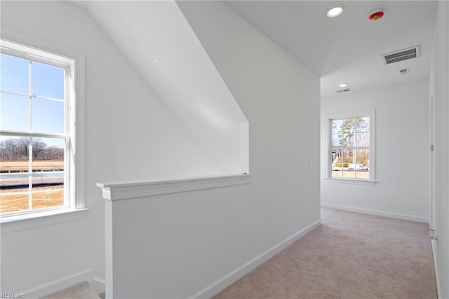 corridor featuring carpet, vaulted ceiling, baseboards, and recessed lighting