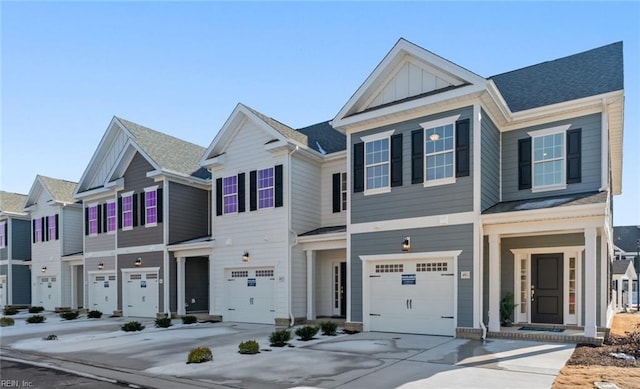 townhome / multi-family property with concrete driveway, board and batten siding, and an attached garage