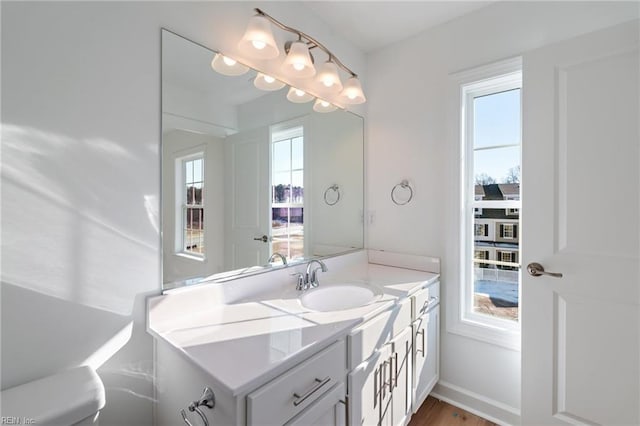 bathroom featuring vanity, baseboards, and wood finished floors