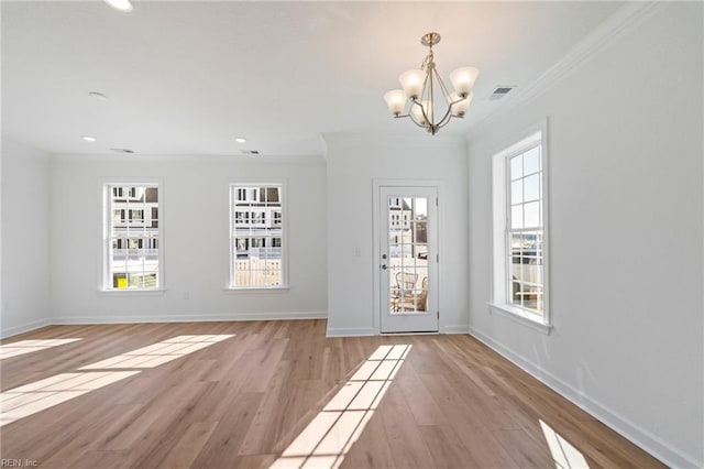 interior space with ornamental molding, light wood finished floors, a wealth of natural light, and baseboards