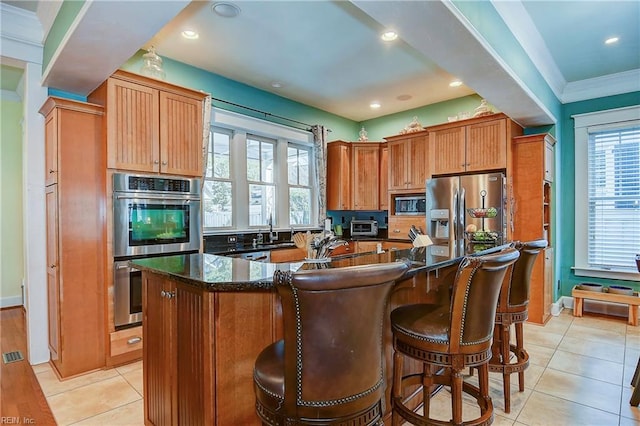 kitchen featuring appliances with stainless steel finishes, a center island, plenty of natural light, and a sink