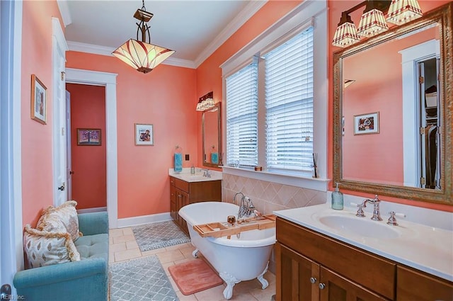 bathroom with a sink, tile patterned flooring, crown molding, a freestanding bath, and two vanities