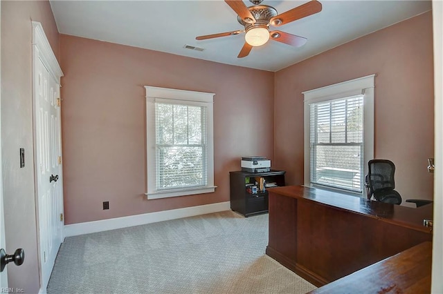 carpeted office space with a ceiling fan, visible vents, and baseboards