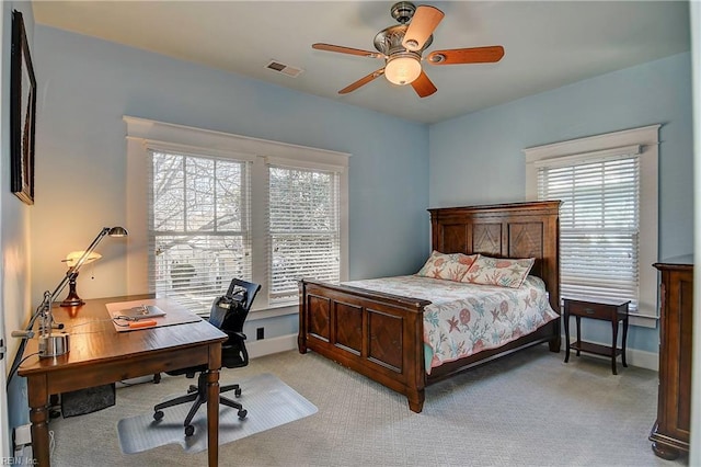 bedroom with light carpet, a ceiling fan, visible vents, and baseboards