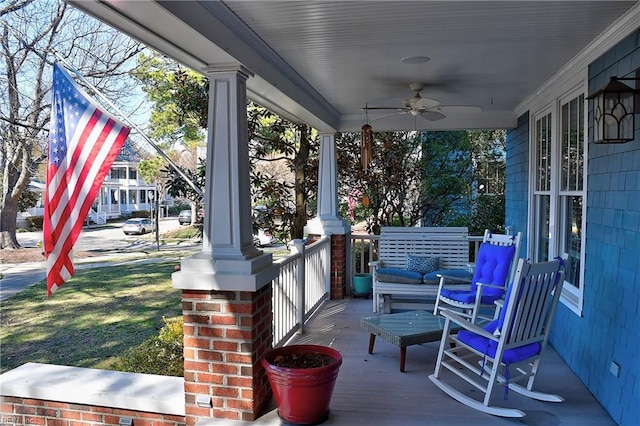 wooden terrace featuring covered porch and ceiling fan