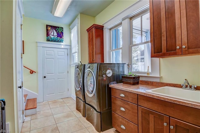 laundry room with light tile patterned floors, separate washer and dryer, a sink, and cabinet space