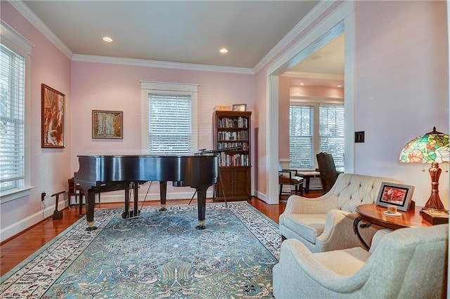 living area with crown molding, baseboards, and wood finished floors