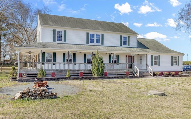 farmhouse inspired home with covered porch, a front yard, and a ceiling fan