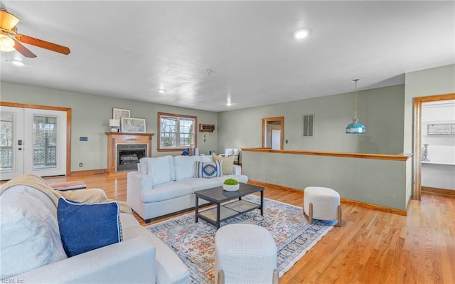 living area with light wood-style floors, a fireplace, and baseboards