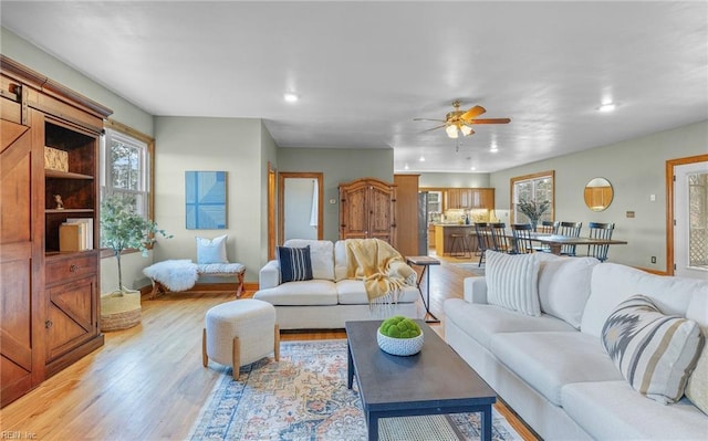 living room featuring recessed lighting, ceiling fan, and light wood-style flooring