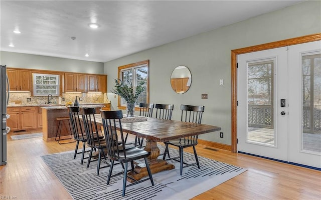 dining room with recessed lighting, french doors, light wood-style flooring, and baseboards