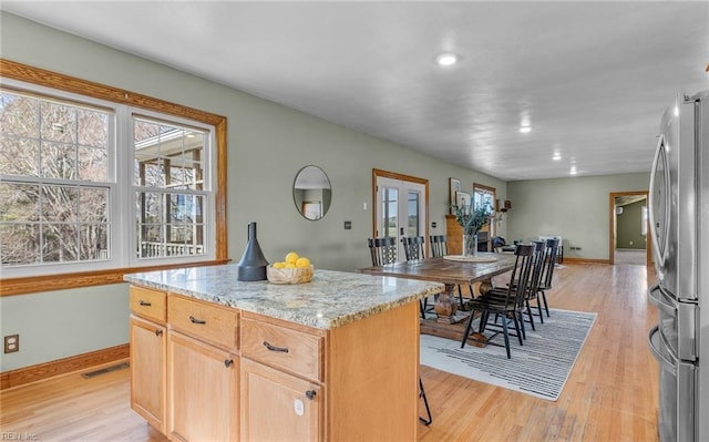 kitchen featuring visible vents, light wood-type flooring, freestanding refrigerator, and a healthy amount of sunlight