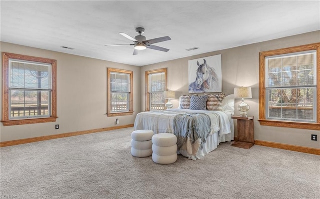 carpeted bedroom featuring multiple windows, visible vents, and baseboards