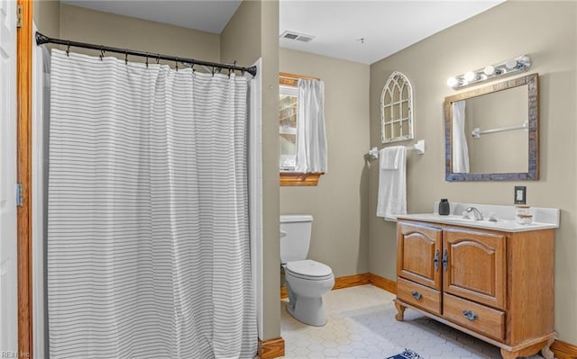 bathroom with visible vents, toilet, vanity, baseboards, and tile patterned floors