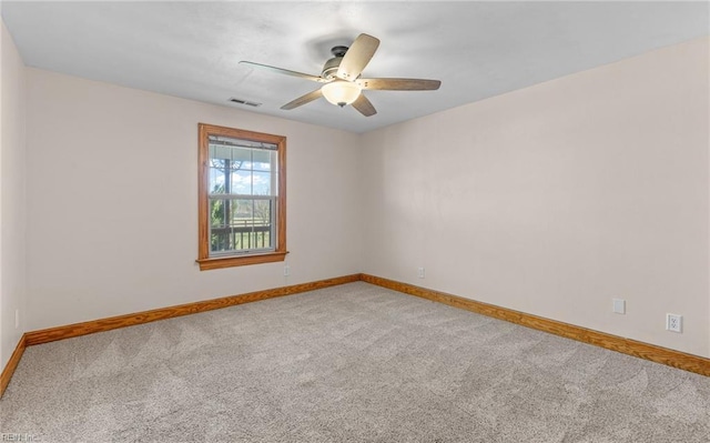 carpeted empty room featuring visible vents, ceiling fan, and baseboards