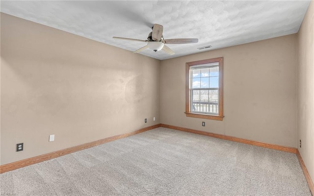 spare room featuring a ceiling fan, carpet, visible vents, and baseboards