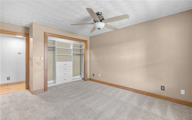 unfurnished bedroom featuring light carpet, a closet, a ceiling fan, and baseboards