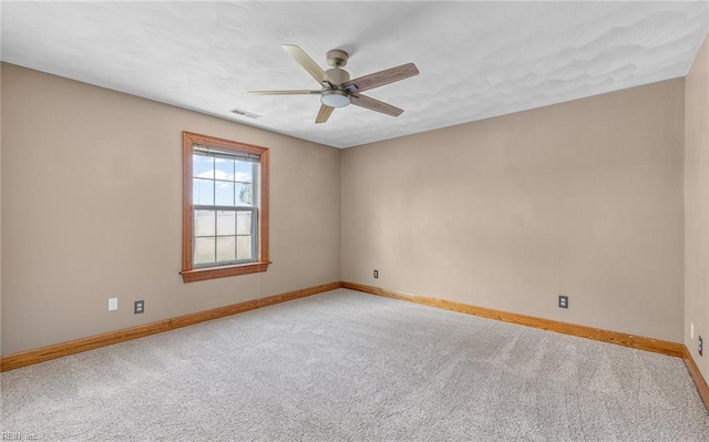 empty room with a ceiling fan, carpet, visible vents, and baseboards