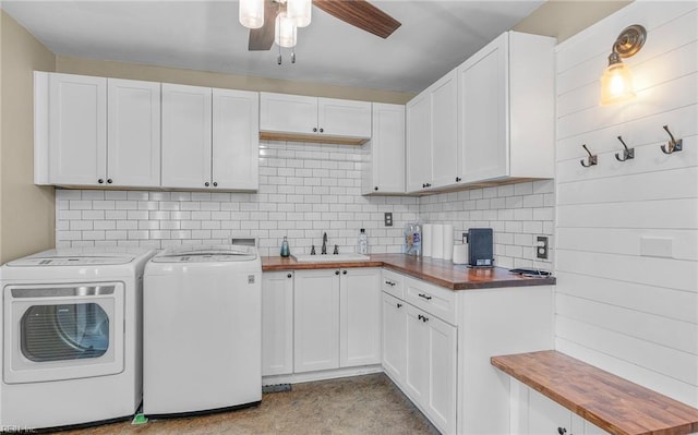 clothes washing area featuring a sink, washing machine and dryer, cabinet space, and a ceiling fan