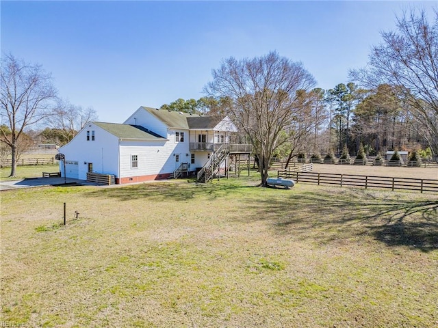 view of yard featuring a garage, stairs, and fence