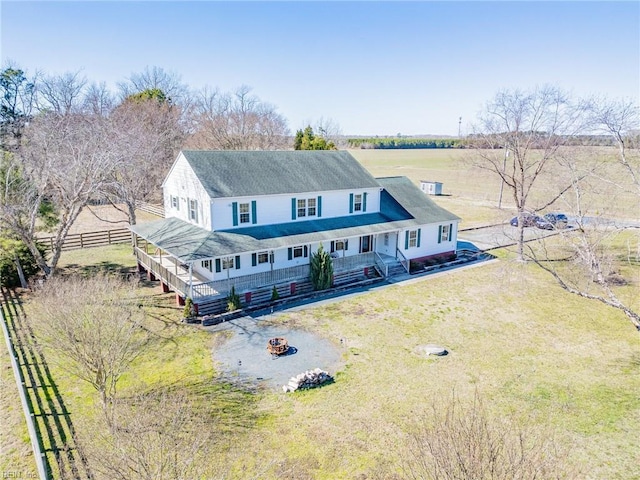 view of front facade featuring covered porch, an outdoor fire pit, fence, and a front yard