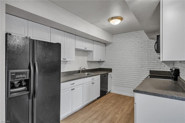 kitchen with black appliances, light wood finished floors, dark countertops, and white cabinets