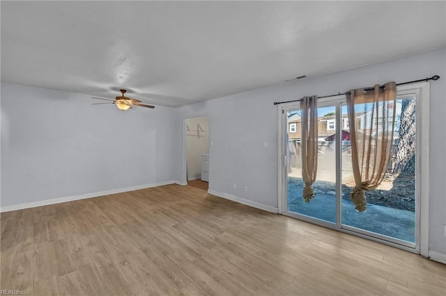 spare room with light wood-style floors, visible vents, ceiling fan, and baseboards